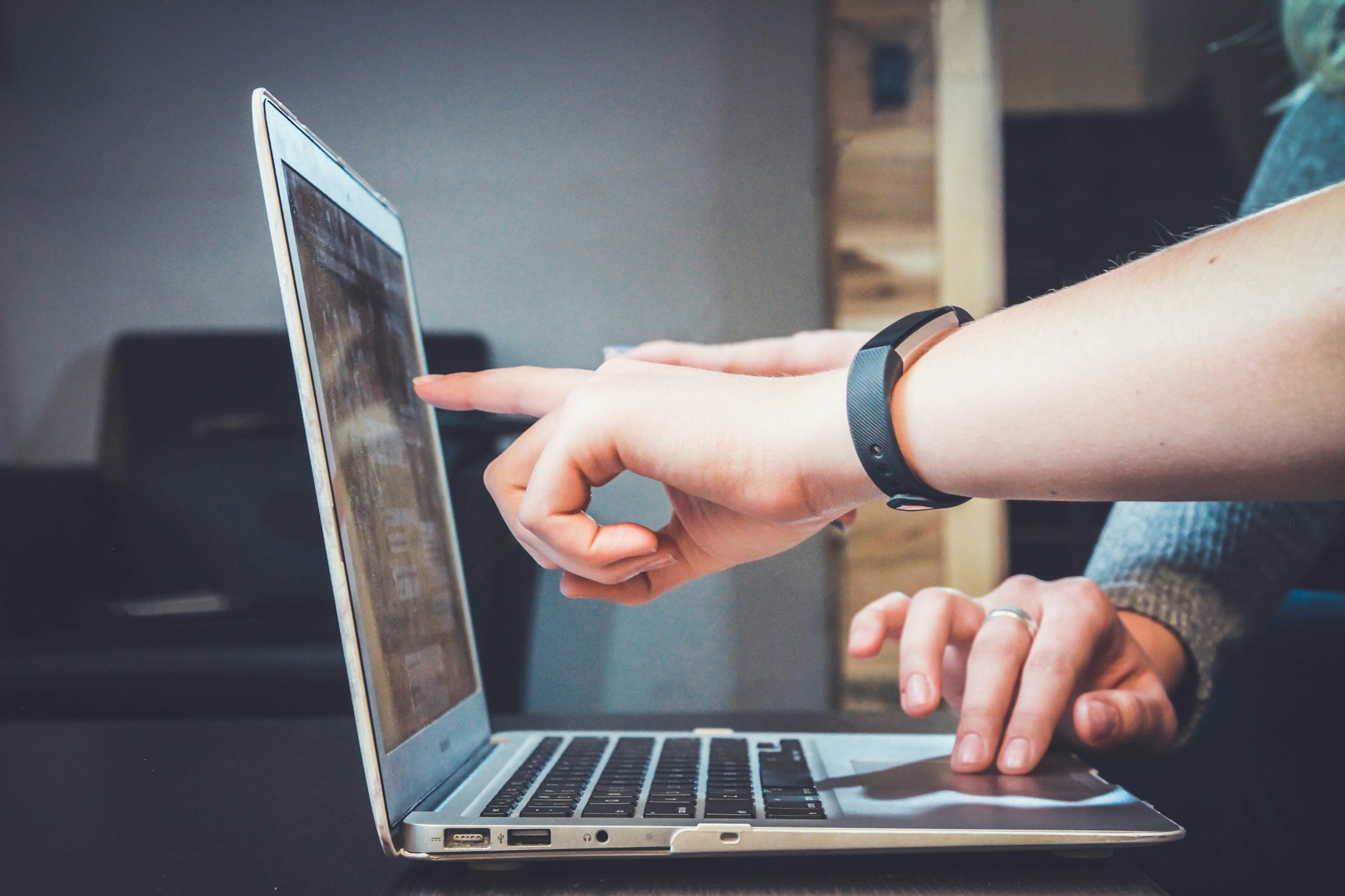 finger pointing at laptop
